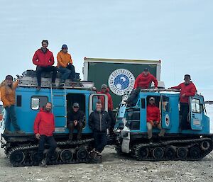 Image of ten expeditioners posing around the SAR-Hagg.