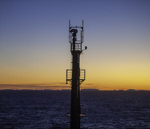 A tall ship tower in front of a beautiful sunset