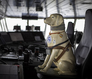 A fibreglass Guide Dogs collection dog, sits on a chair on the bridge of a ship