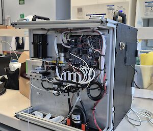 A box-shaped instrument used to collect seawater samples sitting on a laboratory bench.