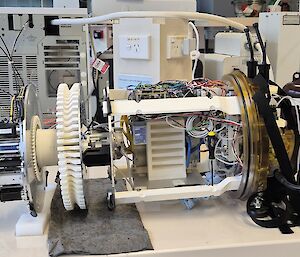 A cylindrical instrument being prepared for installation on a ship, sitting on a laboratory bench.