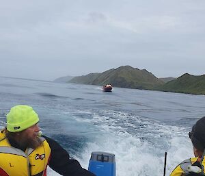 Close up of coxswain driving at the tiller with second IRB in the distance