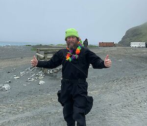 Person dressed for boating operations in black dry suit and wearing a fluro green beanie and a Hawaiian lei