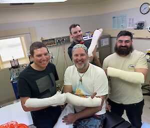 Four men with arms in plaster in a medical clinic
