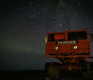 An orange vehicle under a starry sky
