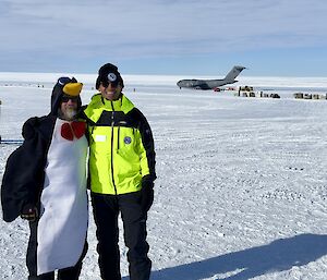 Thom the expeditioner standing next to another expeditioner who is dressed as a penguin.