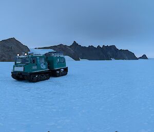 A green tractor against white ice
