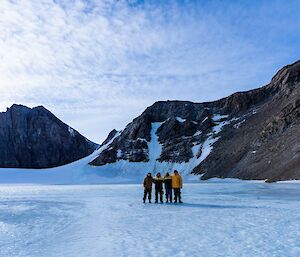 A group of four expeditioners standing on the ice