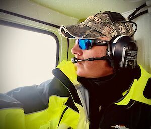 An expeditioner inside a Hagg vehicle looking out at the ice landscape through a window