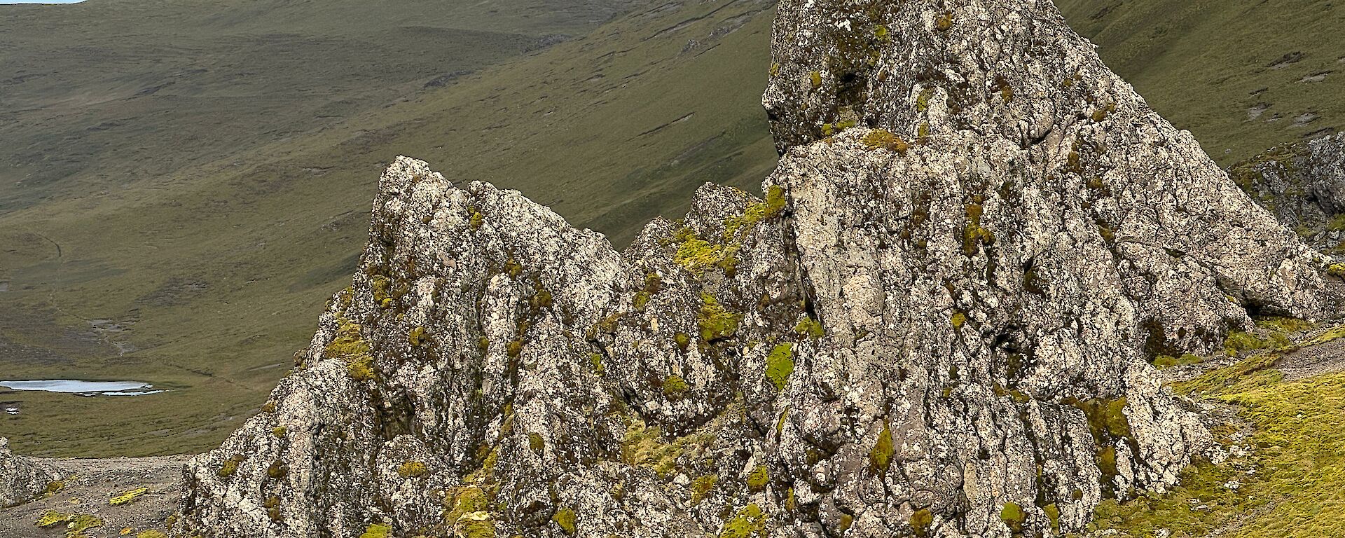 A large jagged triangular rock sticks out from the surrounding hills