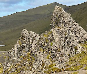A large jagged triangular rock sticks out from the surrounding hills