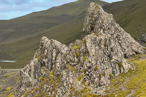 A large jagged triangular rock sticks out from the surrounding hills