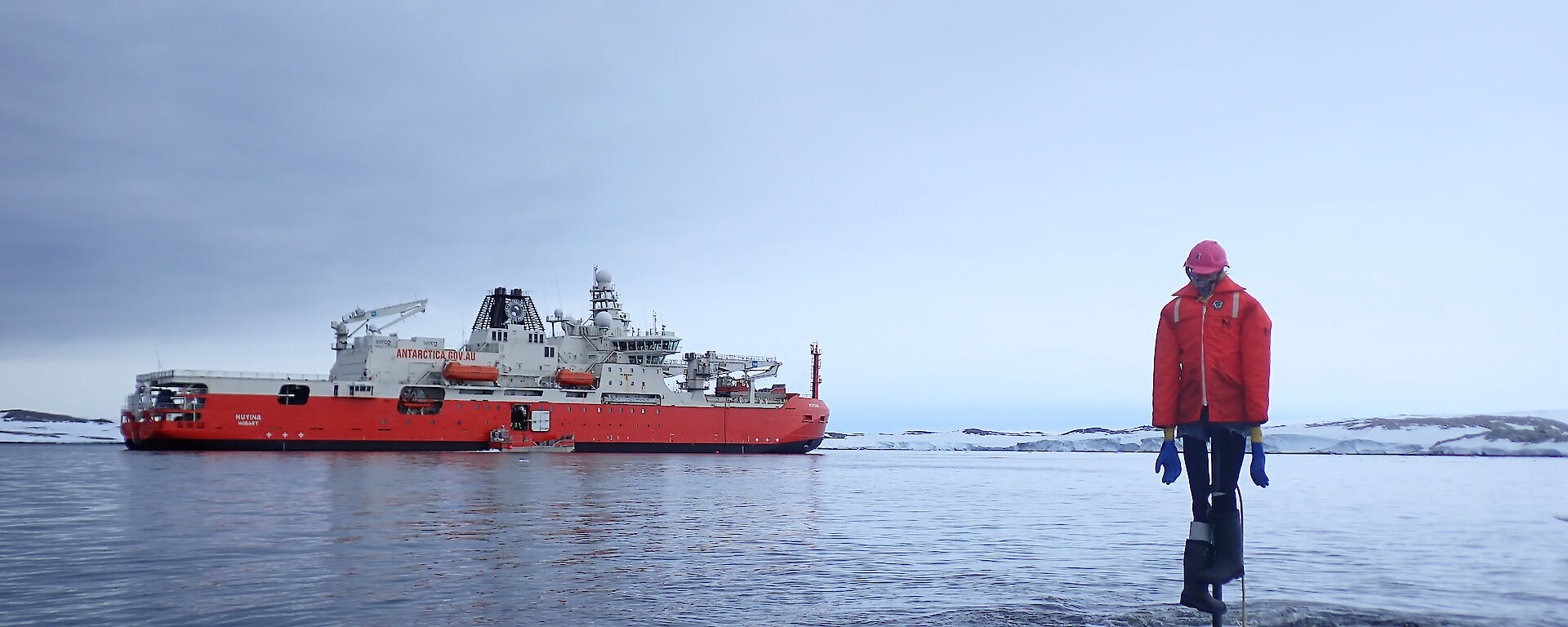 RSV Nuyina, in front of a scarecrow in the water