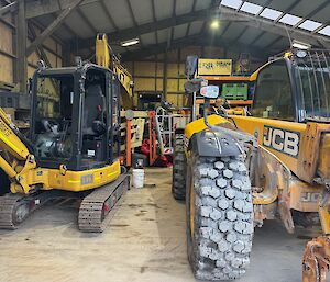 Machinery Shed with excavator on left and JCB parked on right