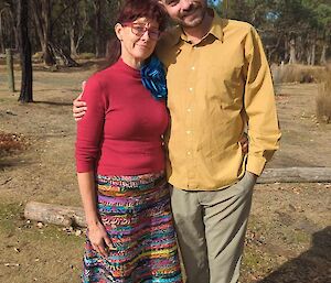 A man and a woman hugging and facing the camera