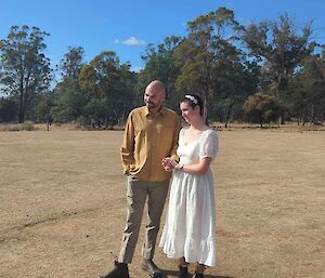 A woman in a wedding dress next to a man