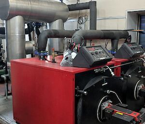 Heating equipment in a big red box with pipes coming out of it
