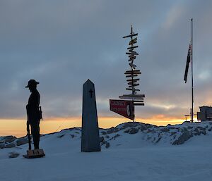 Sun rising with the flagpoles, lone soldier and Casey sign just vsible
