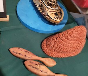 A model ship,  two wooden kitchen implements and a knitted object