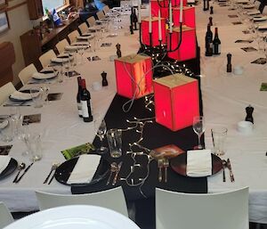 A long table set with cutlery and candles.