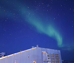 A green Aurora above one of Casey Station's sheds