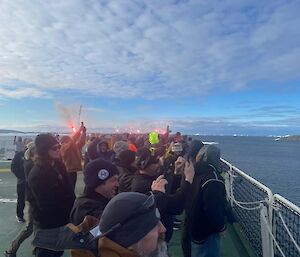people standing on back deck of ship