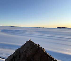 A pointy mountain in the foreground and a snowy slope