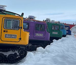 A row of Hägglunds of different colours in Antarctica