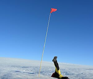 An expeditioner’s legs in the air as if they’ve just fallen over backwards on the ice