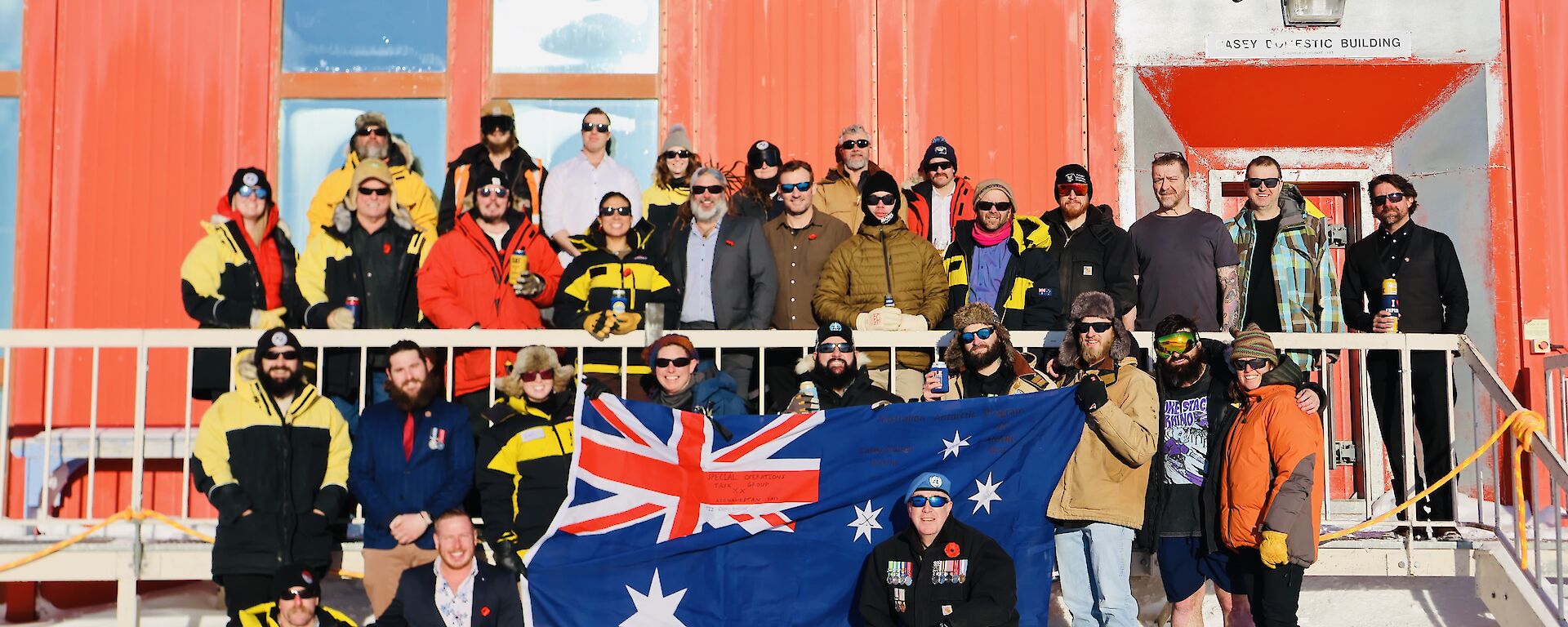 Expeditioners in an ANZAC Day photograph standing outside the Red Shed