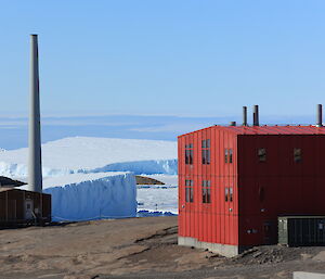 A red shed with icebergs and snow in the background