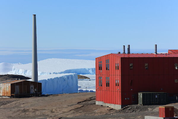 A red shed with icebergs and snow in the background