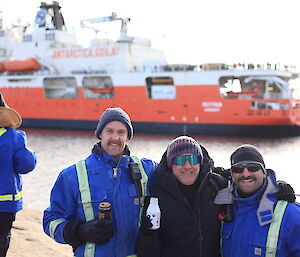 A group of people standing in front of a red and white icebreaker