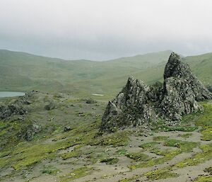 Jagged rocks on the plateau with a small lake in the distance