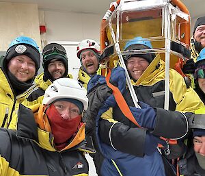 Eight people in yellow Antarctic clothing and helmets