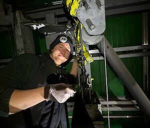 A man wearing beanie and gloves, looking at equipment