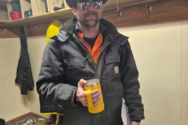 A Casey Station plumber holding a coffee cup getting ready to go to work