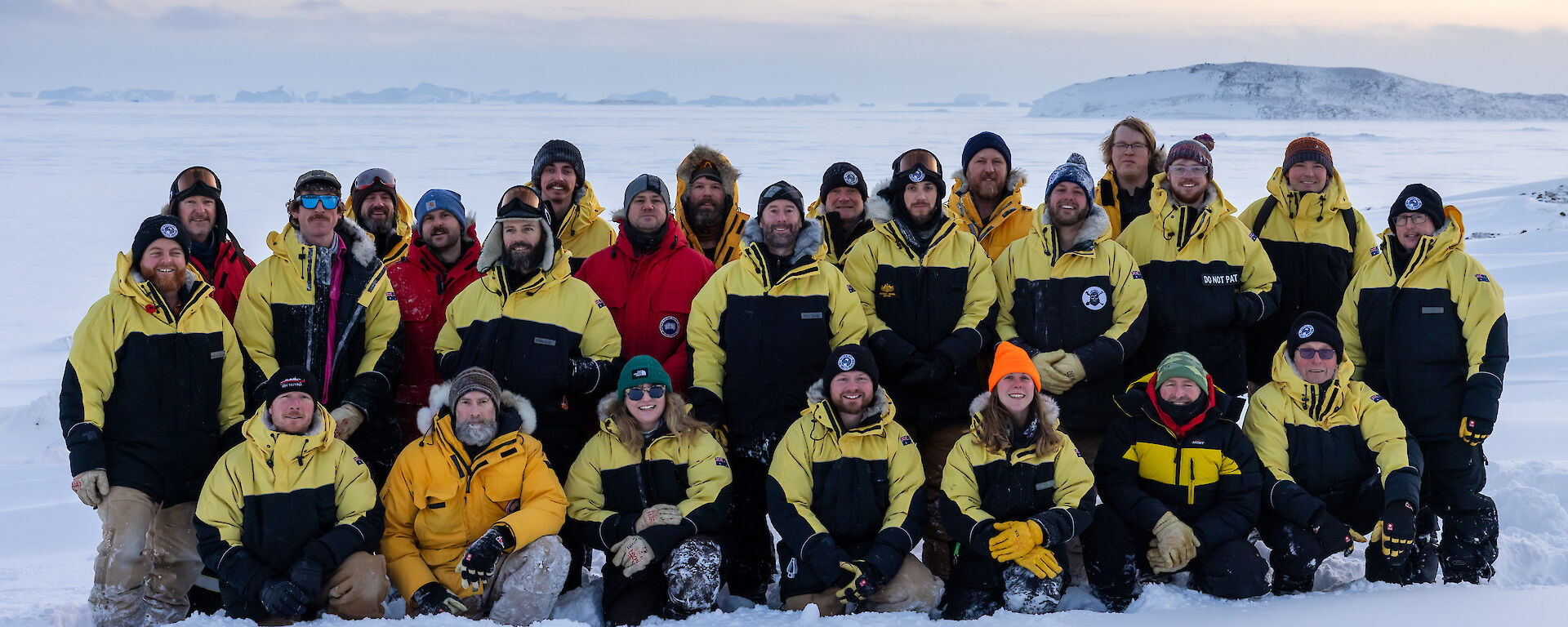 Group of 25 people in a posed photo out on the ice