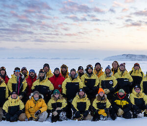 Group of 25 people in a posed photo out on the ice