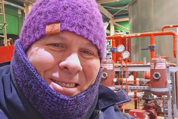 A man wearing many warm layers, including a woolen beanie, neckwarmer and thick jacket.
