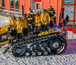 The diesel mechanic team (8 people)  standing on a tractor