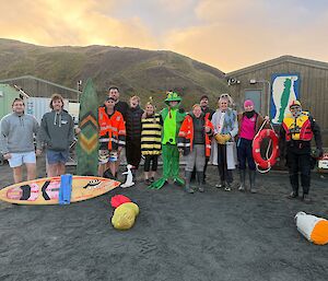 A group of people in colourful swimming attire including accessories such as surfboards and life rings