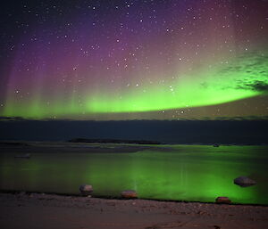 Sheets of green and purple light reflected in the bay
