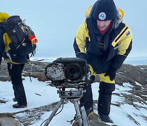 Expeditioners outside with a large camera on a tripod