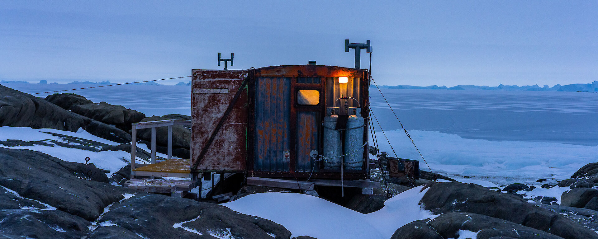 A small hut with the outdoor light on
