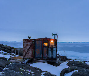 A small hut with the outdoor light on