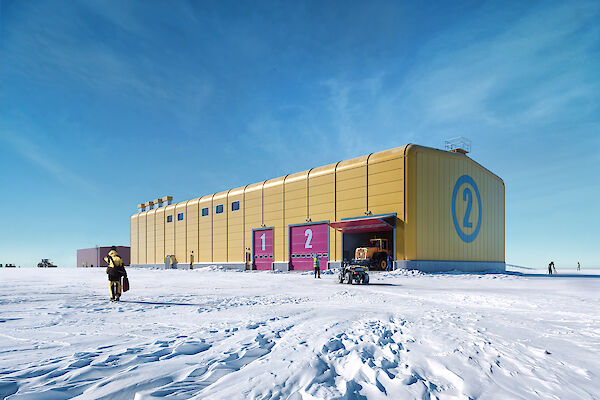 A bright yellow building on the ice under a blue sky
