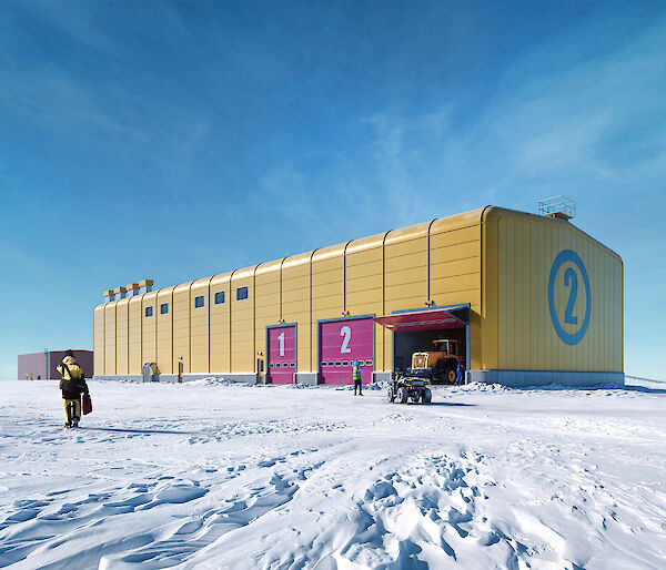 A bright yellow building on the ice under a blue sky