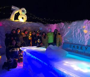 Casey Station outdoor ice bar with expeditioners standing under colourful lights