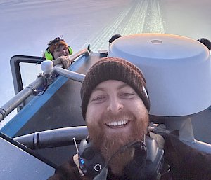 Two people on vehicle on the sea ice